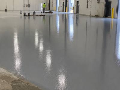 Grey base coat spread across a prepared commercial slab