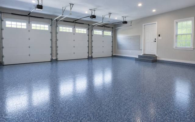 Blue flake epoxy floor running the full width of a three bay garage